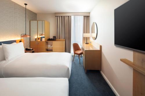 a hotel room with two beds and a flat screen tv at Hilton Garden Inn Bristol City Centre in Bristol
