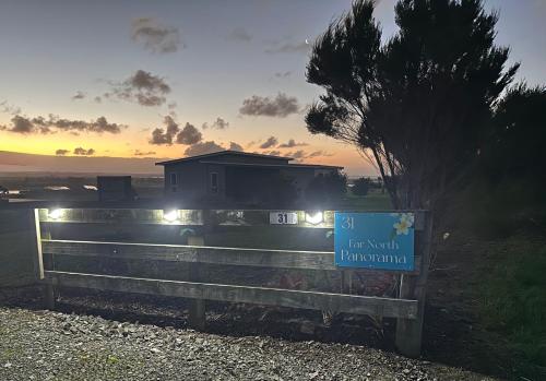 a sign on a fence in front of a house at Far North Panorama in Kaingaroa
