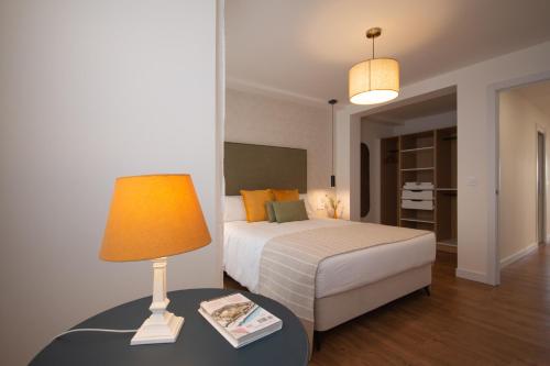 a bedroom with a bed and a lamp on a table at LC Apartaments Trafalgar Puerto & Playa in Grao de Castellón