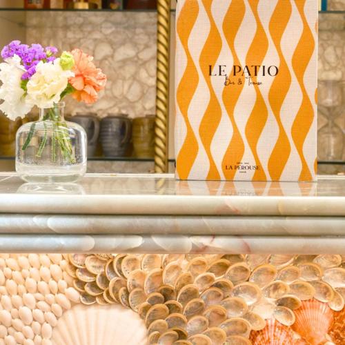 a vase of flowers sitting on a counter with shells at Hôtel La Pérouse Nice Baie des Anges in Nice