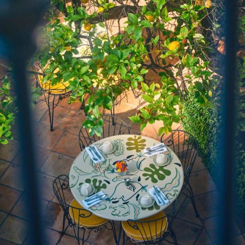 a table with chairs and a table with a plate at Hôtel La Pérouse Nice Baie des Anges in Nice