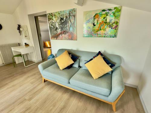 a living room with a blue couch with yellow pillows at Maison des Chênes 64 - Independant apartment with terrasse in Boucau