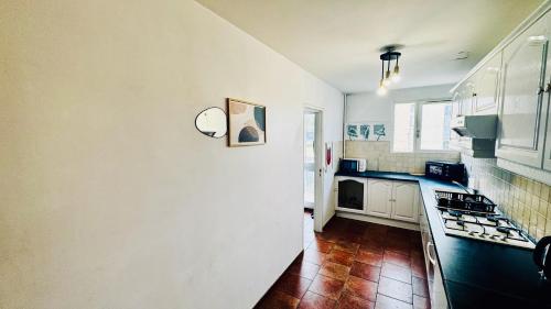 a kitchen with white cabinets and black counter tops at Coeur de Dammarie - Balcon et Parking privé in Dammarie-lès-Lys