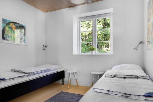 a bedroom with two beds and a window at 16632-Farevejle-Karuphoj-4-C in Fårevejle