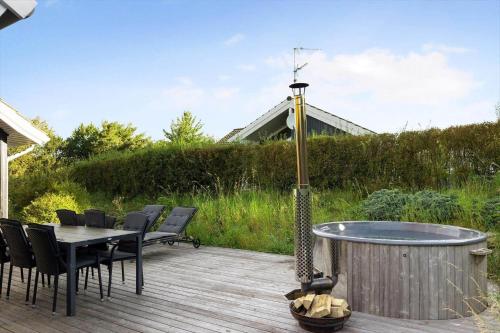 a deck with a table and chairs and a hot tub at 16632-Farevejle-Karuphoj-4-C in Fårevejle