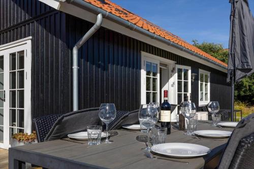 a wooden table with wine glasses on a patio at 16632-Farevejle-Karuphoj-4-C in Fårevejle