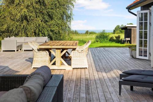 a wooden table and chairs on a patio at 16632-Farevejle-Karuphoj-4-C in Fårevejle
