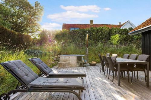 a deck with chairs and a table and a fire pit at 16632-Farevejle-Karuphoj-4-C in Fårevejle
