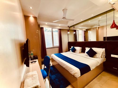 a bedroom with a bed and a television in it at Majesta stays pitampura in New Delhi