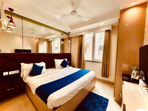 a bedroom with a large bed with blue pillows at Majesta stays pitampura in New Delhi
