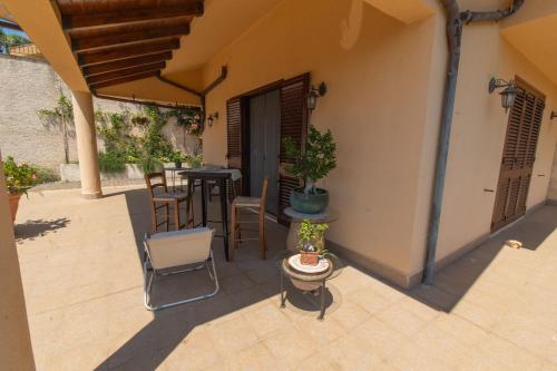 an outdoor patio with chairs and a table and a table at Villa Fiori e Sapori in Messina