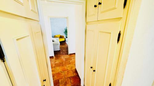a hallway with white cabinets and a living room at Coeur de Dammarie - Balcon et Parking privé in Dammarie-lès-Lys