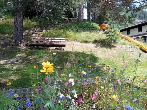 a garden with a park bench and flowers at Landhaus Almidyll in Seefeld in Tirol
