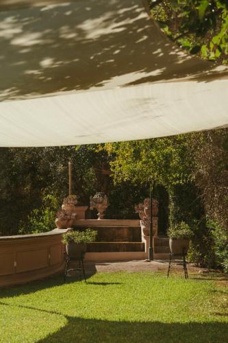 a tent over a lawn with two chairs and a fountain at Rondaia, a Winery & Fincahotel-Agroturismo in Tramuntana in Esporles