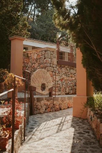 a stone house with a gate and a stone wall at Rondaia, a Winery & Fincahotel-Agroturismo in Tramuntana in Esporles