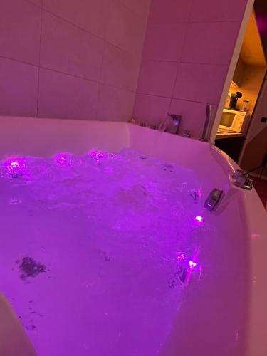 a purple bath tub with pink lights in it at La suite Tournonaise in Tournon-sur-Rhône