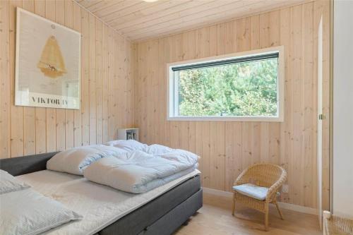 a bedroom with a bed and a window and a chair at 13370-Hojby-Havsbjergvej-11-A in Højby