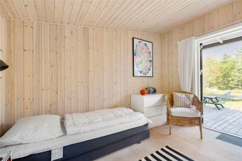 a bedroom with a bed and a chair and a window at 13370-Hojby-Havsbjergvej-11-A in Højby