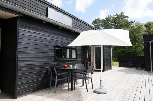 a patio with a table and a white umbrella at 13370-Hojby-Havsbjergvej-11-A in Højby