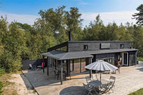 a modular house with a deck and an umbrella at 13370-Hojby-Havsbjergvej-11-A in Højby