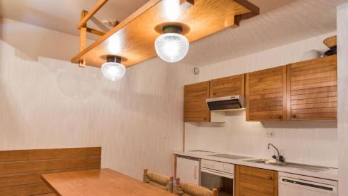 a kitchen with wooden cabinets and a wooden table at Chesa Sarvit 2 - Celerina in Celerina