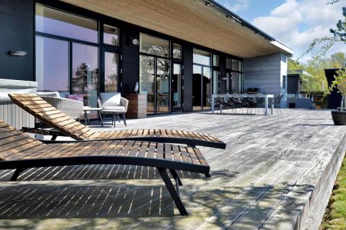 a wooden deck with chairs and tables on a house at 18007-Holbaek-Fjorddalsvej-27 in Holbæk