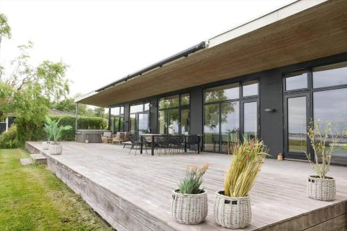 a patio with potted plants in front of a house at 18007-Holbaek-Fjorddalsvej-27 in Holbæk