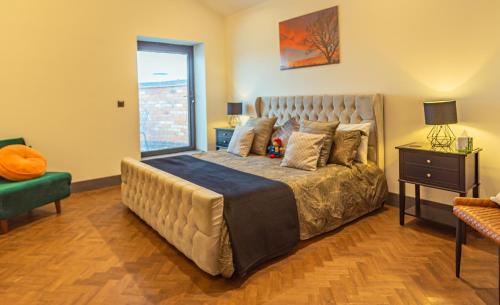 a bedroom with a large bed and a window at Marmalade Barn Guest Suite with wet room in Rugeley