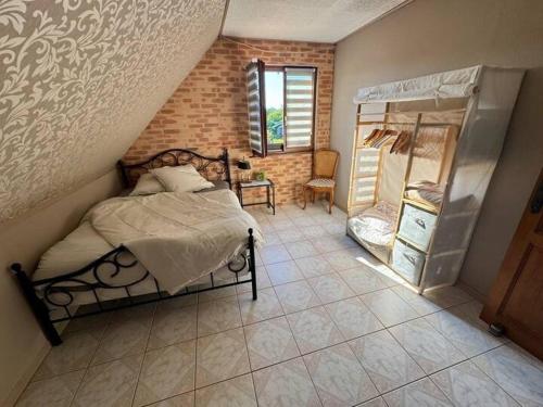 a bedroom with a bed and a brick wall at Maison familiale, authentique, confort et calme in Sundhoffen