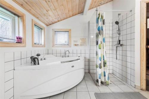 a white bathroom with a tub and a shower at 13392-Hojby-Herlufholmsvej-13 in Højby