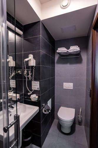 a bathroom with a toilet and a sink and a phone at Hotel Alibaba in Humenné