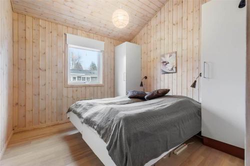a bedroom with wooden walls and a bed with a window at 13392-Hojby-Herlufholmsvej-13 in Højby