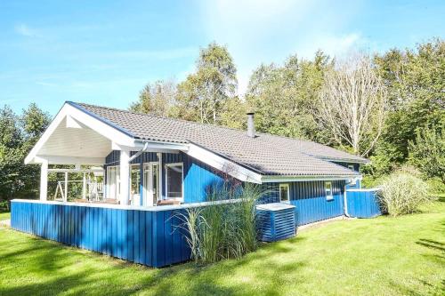 a house with a blue fence in a yard at 13392-Hojby-Herlufholmsvej-13 in Højby