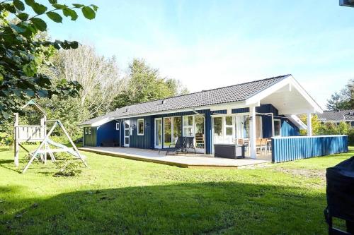 a blue house with a playground in a yard at 13392-Hojby-Herlufholmsvej-13 in Højby
