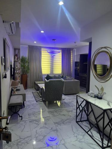 a living room with a couch and a mirror at Orbit Apartments in Lagos