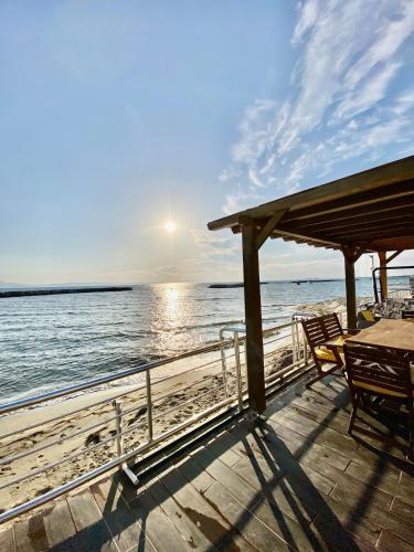 a dock with a table and chairs on the water at Ayvalik Seafront Villa Mansion Summer House in Ayvalik in Ayvalık