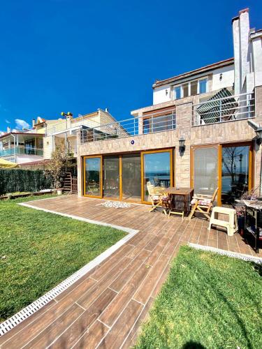 a house with a large patio with grass at Ayvalik Seafront Villa Mansion Summer House in Ayvalik in Ayvalık