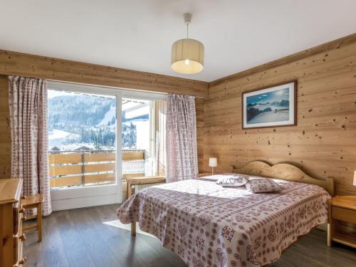 Un dormitorio con una cama y una ventana grande en Luminosité et espace, 2 pièces, centre village, proche pistes, ascenseur - FR-1-304-14, en La Clusaz