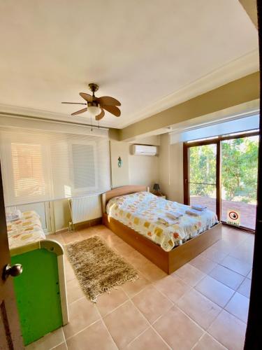 a bedroom with a bed and a ceiling fan at Ayvalik Seafront Villa Mansion Summer House in Ayvalik in Ayvalık