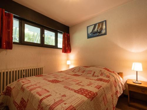 Un dormitorio con una cama y dos lámparas y dos ventanas. en 2 Pièces 4 Pers, Proximité commerces, Garage et Ascenseur - FR-1-304-12, en La Clusaz