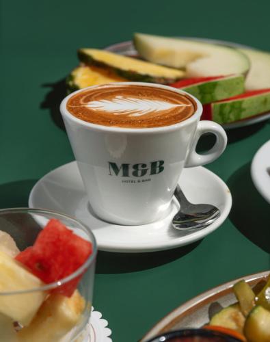 a cup of coffee and a plate of food at Hotel Malcom and Barret in Valencia