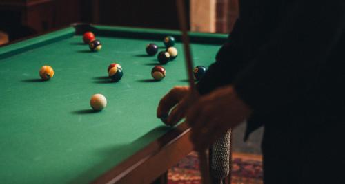 a man playing a game of pool on a pool table at Hällsnäs Hotell & Restaurang in Mölnlycke