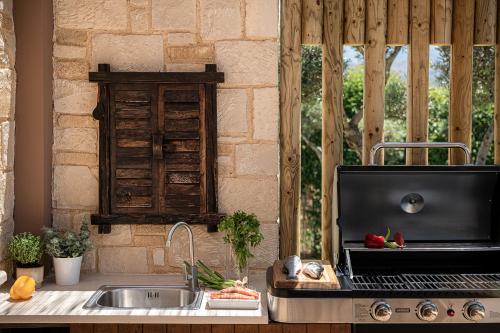 a kitchen with a sink and a stove top oven at Villa Peacock with Spa Facilities in Daratso