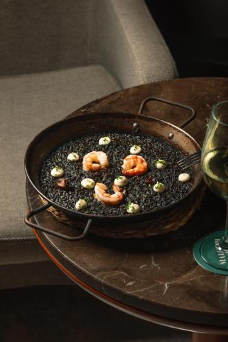 a pan with shrimp and other ingrediants on a table at Hotel Malcom and Barret in Valencia