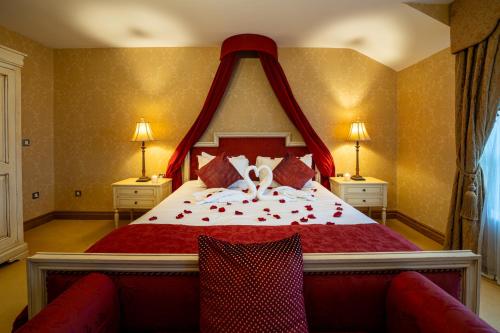 a bedroom with a large bed with roses on it at Kettles Country House Hotel in Swords