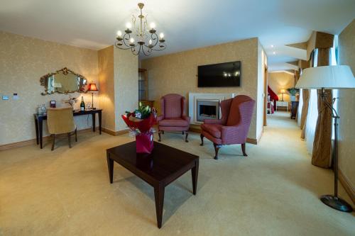 a living room with chairs and a table and a television at Kettles Country House Hotel in Swords