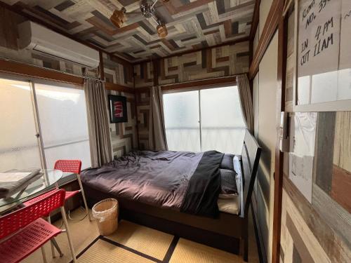 a bedroom with a bed in a room with a window at Haneda Artistic House in Tokyo