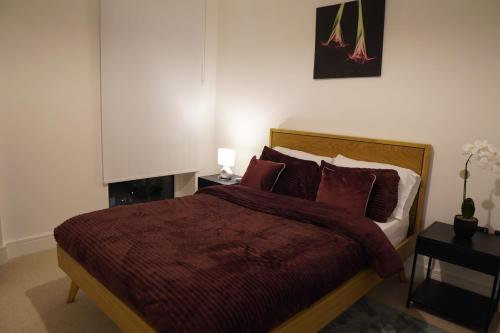 a bedroom with a bed with a red comforter at Cozy 1 bedroom flat in city centre in Birmingham