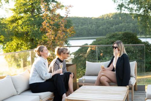 three women sitting around a table on a patio at Hällsnäs Hotell & Restaurang in Mölnlycke