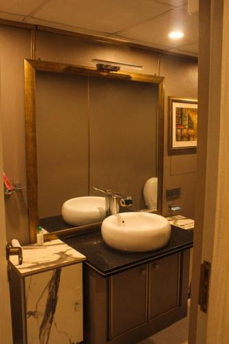 a bathroom with two sinks and a large mirror at Airport Hotel in Karachi